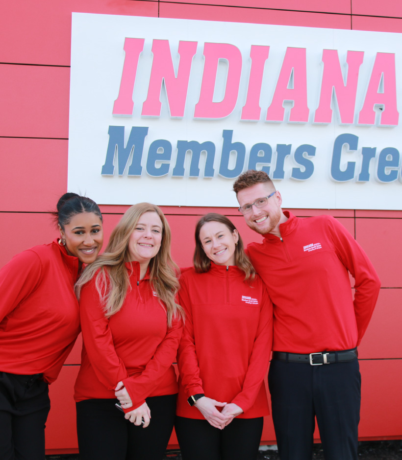 four IMCU employees in front of red branch