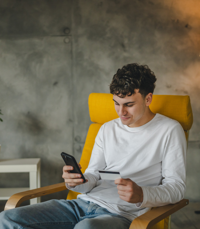 person looking at card and phone
