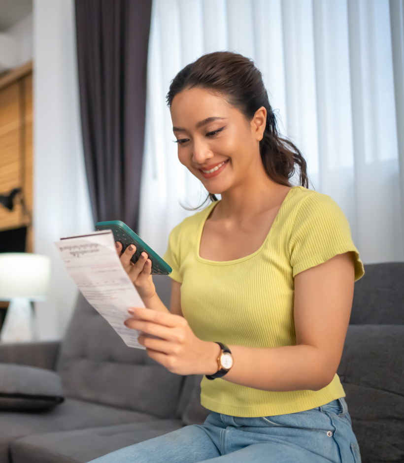 person looking at their phone with paperwork