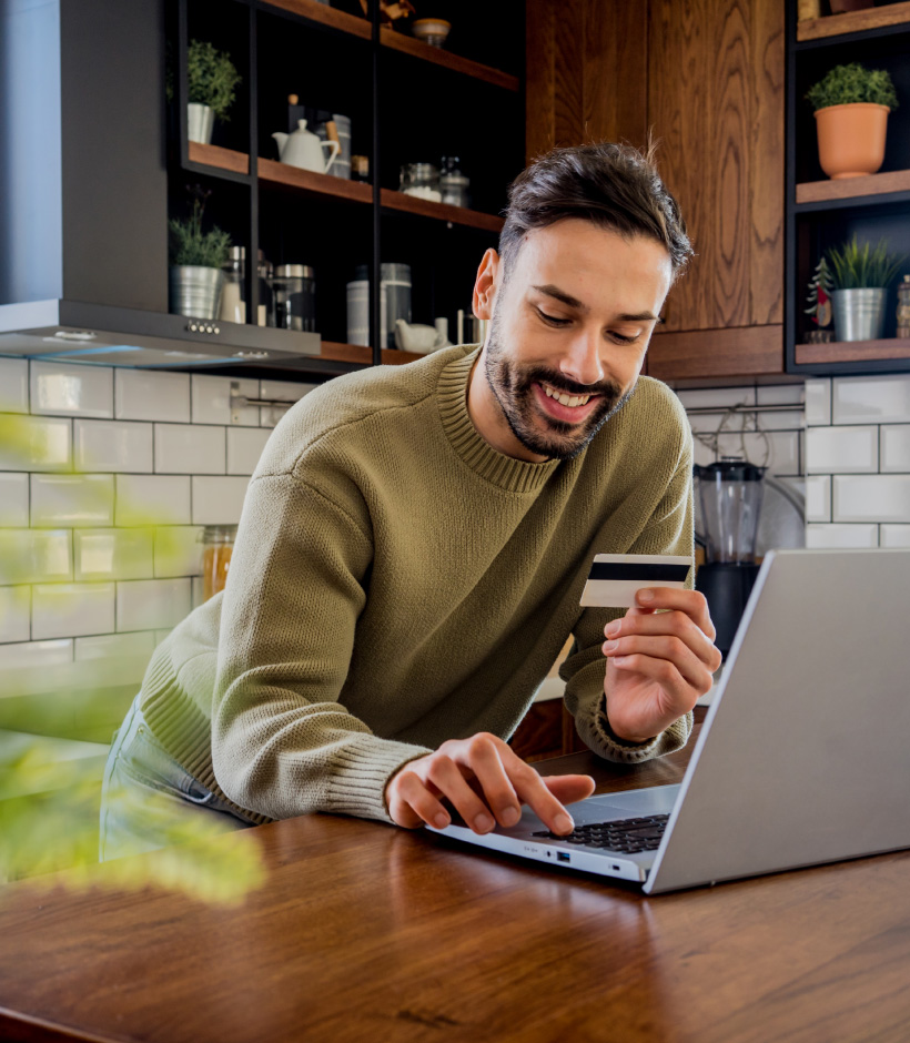 person looking at card and laptop