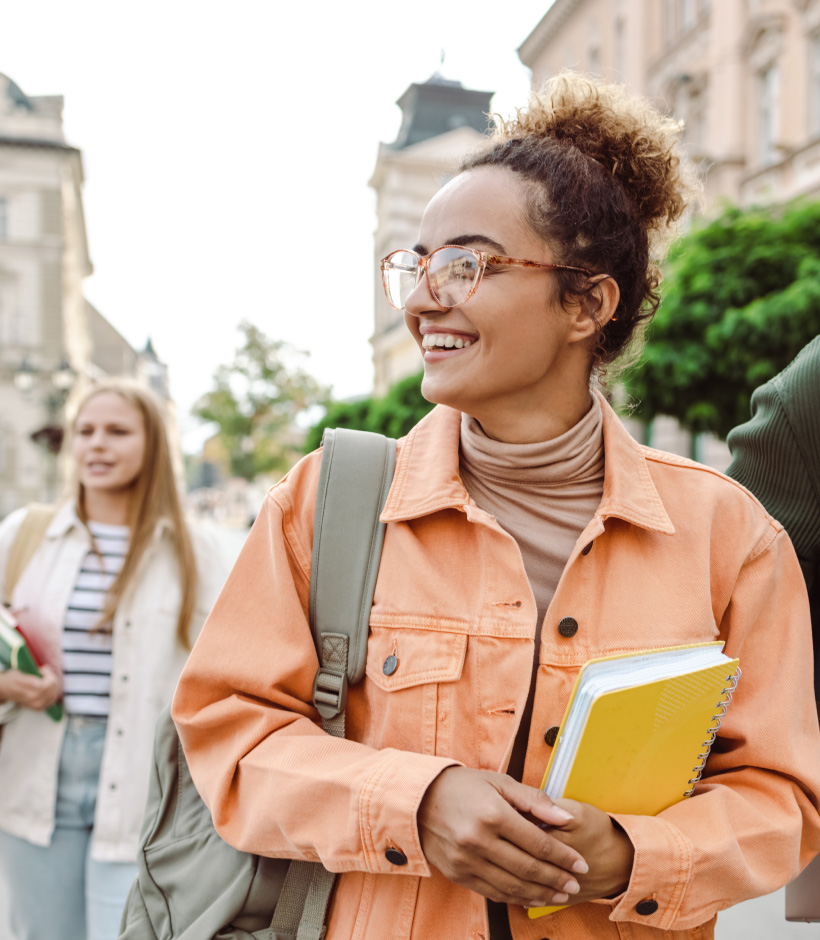 student holding backpack and notebook
