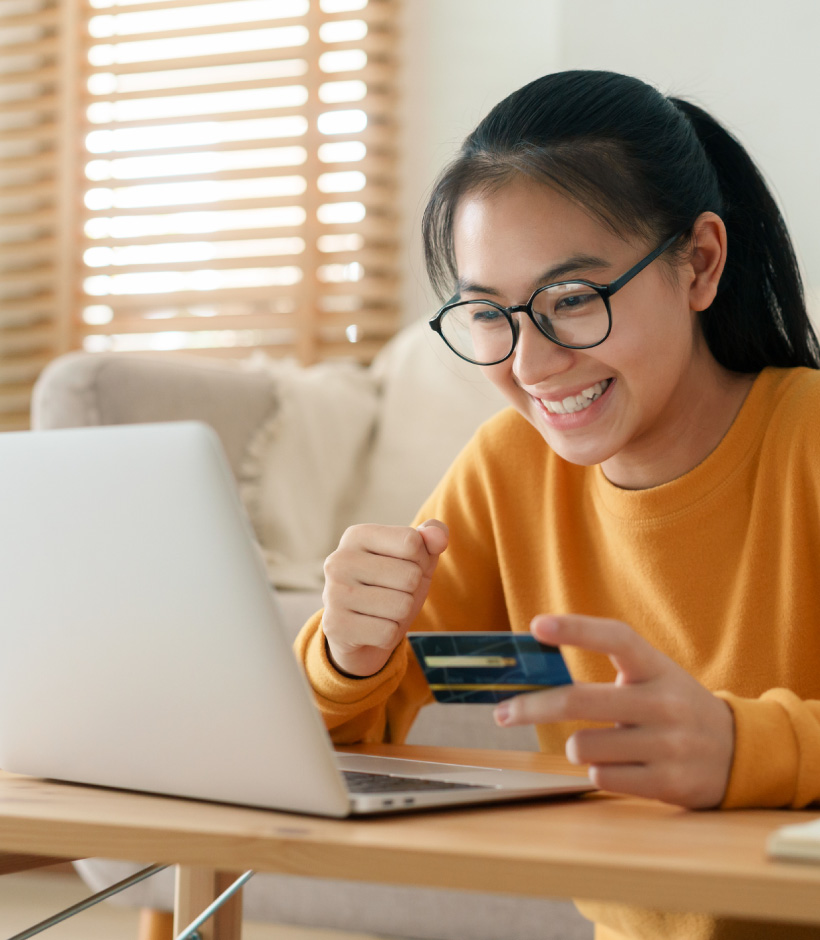 lady looking at credit card over laptop