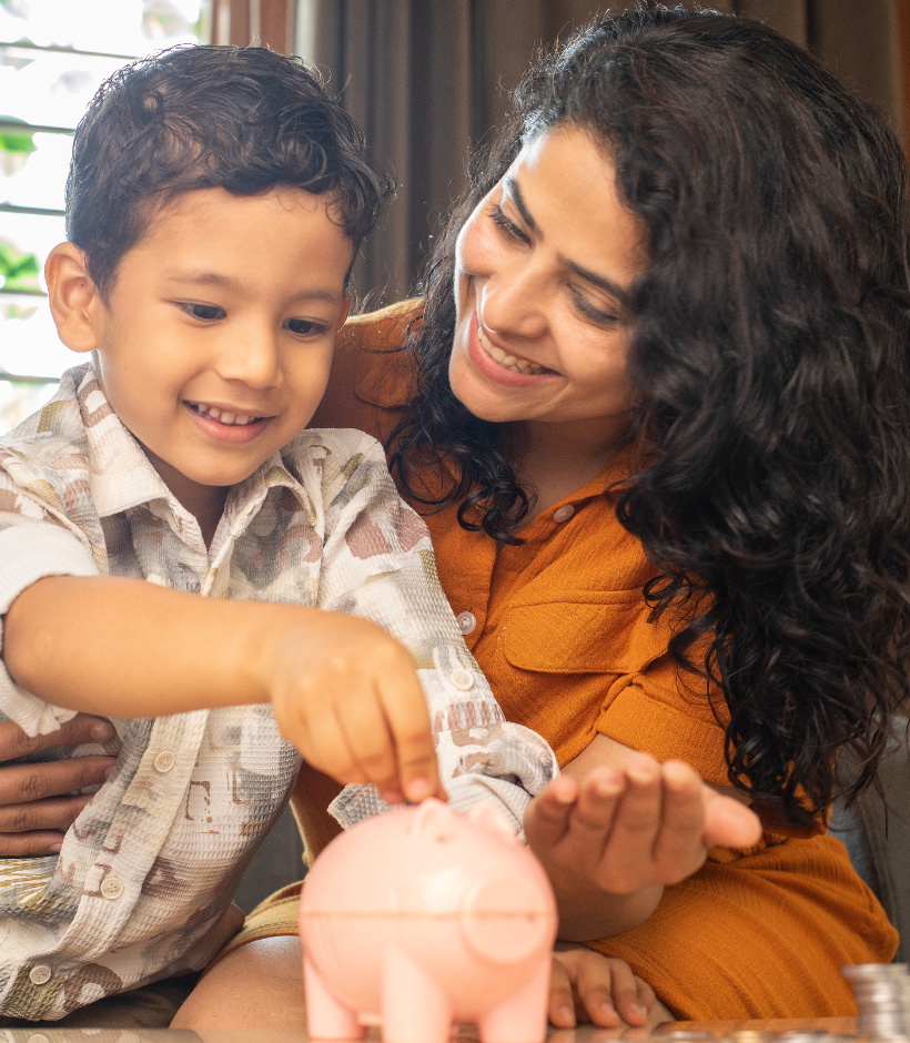 mom and boy putting money in piggy bank
