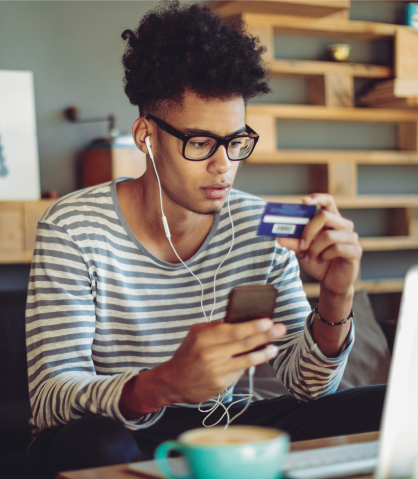 person looking at credit card with phone in hand